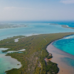 Crystal blue ocean divided by island in Tulum Mexico